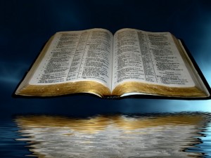 open_bible_over_black_and_blue_clouds_with_reflection